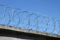 Concertina wire security barrier on a concrete fence