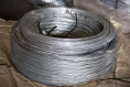 Tension wire coil for barbed wire mounting